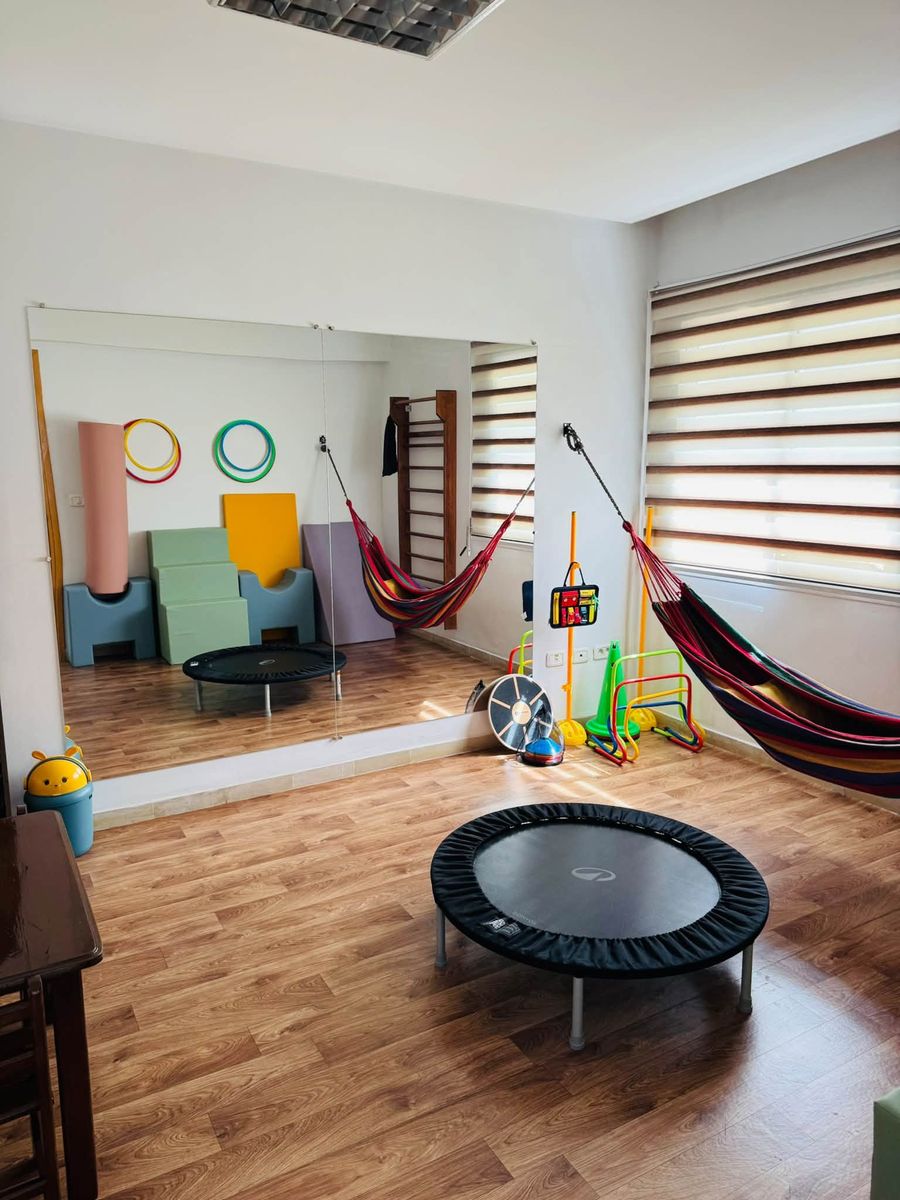 Salle de psychomotricité avec trampoline, hamac, espalier et miroir